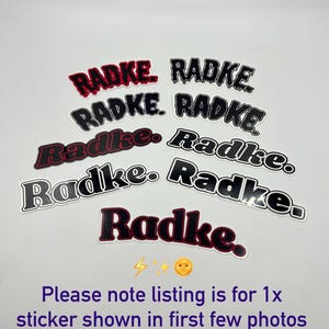 May include: Multiple black and red stickers with the word "Radke" written in a dripping font. The text "Please note listing is for 1x sticker shown in first few photos Showing rest available here" is written below the stickers.