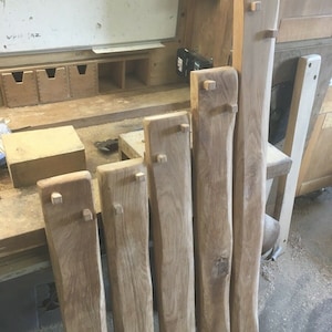 May include: Six wooden planks with square cutouts at the ends. The planks are all different lengths and have a natural wood finish.