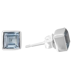 May include: A pair of silver stud earrings with a square blue gemstone.