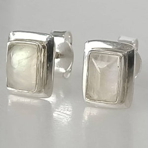 Puede incluir: Un par de pendientes de plata con piedras rectangulares de piedra lunar blanca.