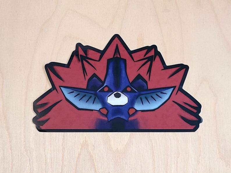 May include: A sticker featuring a stylized illustration of a red and blue creature with sharp teeth and glowing red eyes. The creature is surrounded by a red, spiky halo.