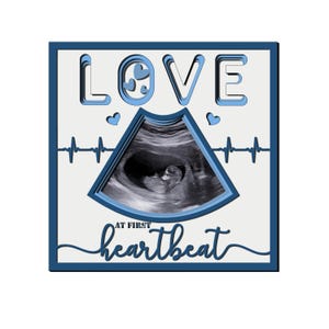 May include: A blue and white framed image with the word "LOVE" in a layered font. The image features a sonogram with a heartbeat line and the text "AT FIRST heartbeat".