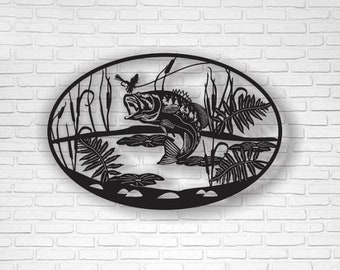 May include: Black metal wall art depicting a bass fish jumping out of the water with reeds and lily pads surrounding it.