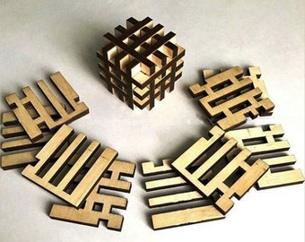 May include: A wooden puzzle cube with a dark brown grid design, surrounded by several disassembled wooden pieces. The pieces are light brown with a slotted design. The cube is assembled, showcasing the puzzle's structure.