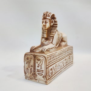 Egyptian Sphinx. Statue of the Great Sphinx sitting on a pedestal engraved with hieroglyphs. Made in Egypt