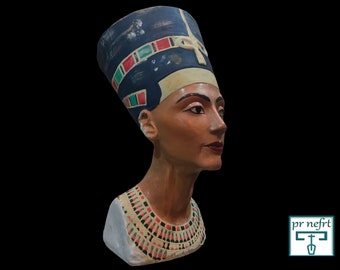 May include: A bust of Queen Nefertiti, an ancient Egyptian queen, with a blue and gold headdress and a colorful necklace. The bust is made of painted plaster and is a replica of the famous bust of Nefertiti.