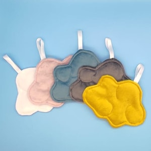 Può includere: Cinque giocattoli di peluche a forma di nuvola in diversi colori, tra cui bianco, rosa, blu, grigio e giallo. Ogni nuvola ha un anello per appenderla.