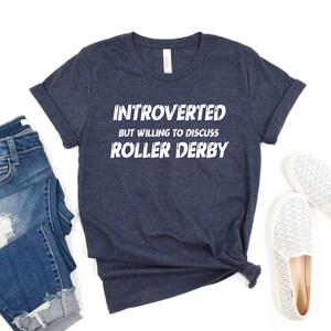 May include: A navy blue t-shirt with the text "Introverted but willing to discuss Roller Derby" in white.