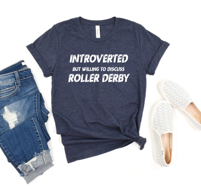 May include: A navy blue t-shirt with the text "Introverted but willing to discuss Roller Derby" in white.