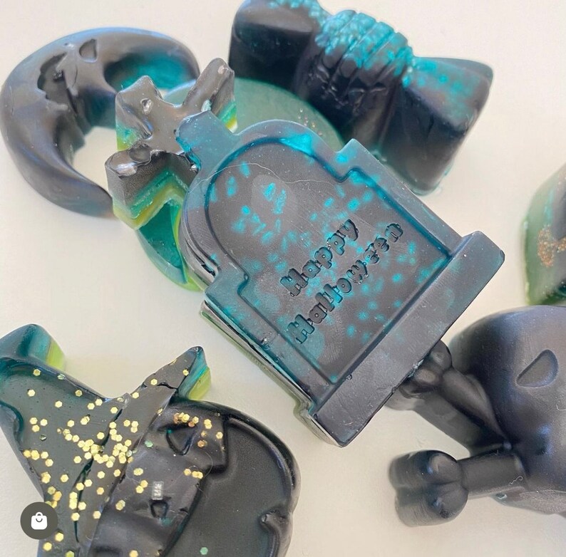 Puede incluir: Un juego de seis jabones con tem&aacute;tica de Halloween. Los jabones son negros y verdes con purpurina y presentan una variedad de dise&ntilde;os espeluznantes, que incluyen una luna creciente, una l&aacute;pida, un sombrero de bruja y una calavera. El jab&oacute;n de la l&aacute;pida dice "Happy Halloween".
