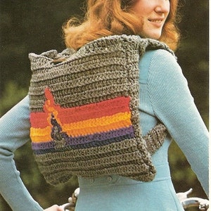 May include: A grey crocheted backpack with a colourful striped design on the back. The backpack has a strap that goes over the shoulder.