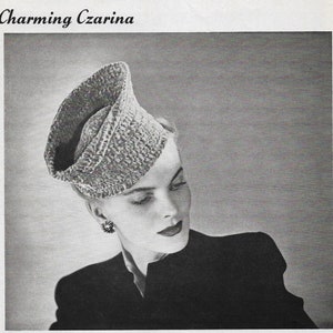 May include: A black and white image of a woman wearing a textured, light-colored hat. The hat has a unique, folded design. The text "Charming Czarina" is at the top of the image. The woman is wearing a dark-colored jacket and earrings.