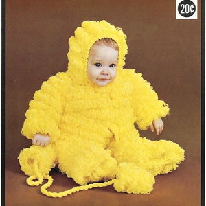 May include: A yellow knitted baby outfit with a hood, resembling a chick. The outfit has a fluffy texture and is complete with a matching pair of booties.