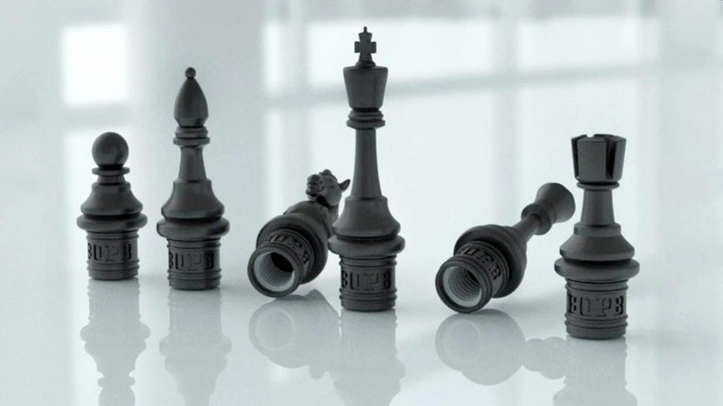 Pu&ograve; includere: Sei pezzi degli scacchi neri, tra cui un re, una regina, un pedone e un cavallo, sono disposti su una superficie bianca. Ogni pezzo ha un design unico e presenta la parola "BUP3" incisa sulla base.