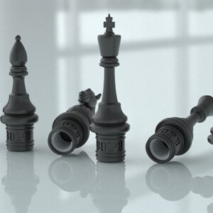 Pu&ograve; includere: Sei pezzi degli scacchi neri, tra cui un re, una regina, un alfiere, un pedone e due torri, sono disposti su una superficie bianca. I pezzi sono realizzati in un materiale nero liscio e hanno un design dettagliato. I pezzi sono tutti in posizioni diverse, alcuni in piedi e altri sdraiati di lato.