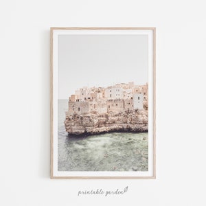 Italian seaside wall art featuring a village with white houses perched on cliffs. A travel-inspired coastal print perfect for Mediterranean, rustic, or modern interiors.