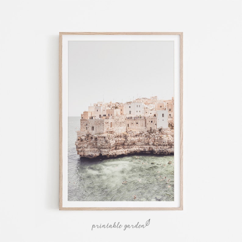 Italian seaside wall art featuring a village with white houses perched on cliffs. A travel-inspired coastal print perfect for Mediterranean, rustic, or modern interiors.