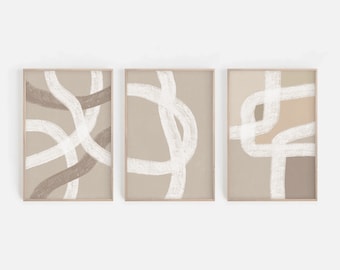 May include: Set of three abstract art prints with white lines on a beige background. The prints are framed in a light wood frame.