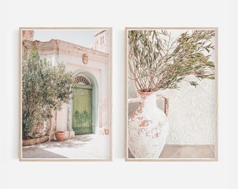 Puede incluir: Dos impresiones enmarcadas, una que muestra una puerta verde con un arco blanco y una pared blanca, y la otra que muestra un jarrón blanco con ramas verdes contra una pared blanca.