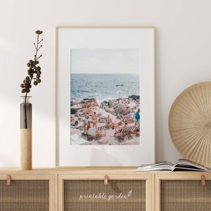 Amalfi Coast print displayed above a sofa in a living room. The soft pastel hues and seaside architecture bring relaxed Italian charm and sunny coastal elegance to your space. Instant digital download, print-ready.