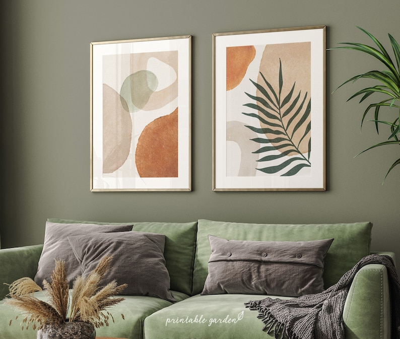 Set of two abstract botanical prints with earth-tone shapes and a deep green palm leaf. Modern boho wall art for neutral or nature-inspired interiors.