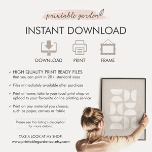 May include: Printable wall art featuring a geometric design with white shapes on a gray background. The art is framed in a black frame and is being held by a person. The text "INSTANT DOWNLOAD" is at the top of the image. The text "DOWNLOAD, PRINT, FRAME" is below the image. The text "HIGH QUALITY PRINT READY FILES that you can print in 20+ standard sizes" is below the text "FRAME". The text "Files immediately available after purchase" is below the text "HIGH QUALITY PRINT READY FILES". The text "Print at home, take to your local print shop or upload to your favourite online printing service" is below the text "Files immediately available after purchase". The text "Print on any material you choose, such as paper, canvas or fabric" is below the text "Print at home, take to your local print shop or upload to your favourite online printing service". The text "Please see this listing's description for more details." is below the text "Print on any material you choose, such as paper, canvas or fabric". The text "TAKE A LOOK AT MY SHOP: www.printablegardenco.etsy.com" is below the text "Please see this listing's description for more details."