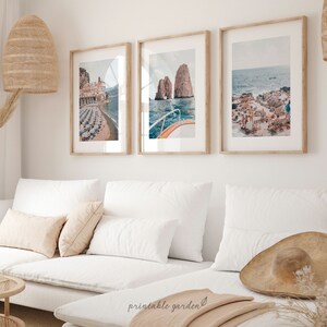 May include: Three framed photographs of coastal scenes. The first photo shows a building with a beach and umbrellas. The second photo shows a boat in the water with a rocky island in the background. The third photo shows a beach with people and umbrellas.