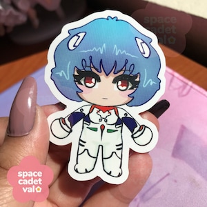 May include: A sticker featuring a cartoon character with blue hair, red eyes, and a white and green suit. The character is a chibi style version of a popular anime character.