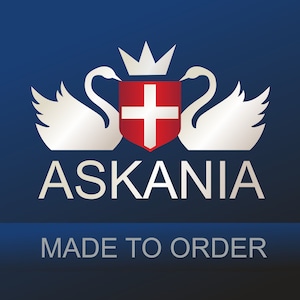 May include: A silver logo with two white swans flanking a red shield with a white cross. The logo is set against a dark blue background and the text "ASKANIA MADE TO ORDER" is below the logo.