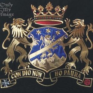Puede incluir: Un escudo de armas bordado en oro con dos leones, un escudo con fondo azul y estrellas doradas, y una corona con joyas rojas. El escudo representa un le&oacute;n dorado y monta&ntilde;as. El escudo de armas incluye una cinta dorada con el texto "CON DIO NON HO PAURA".