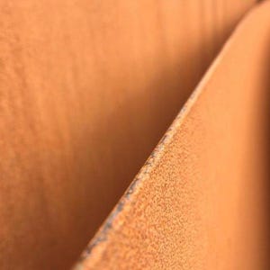 May include: Close-up of two pieces of rusted metal, showing the texture of the rust and the way the metal has been folded over.