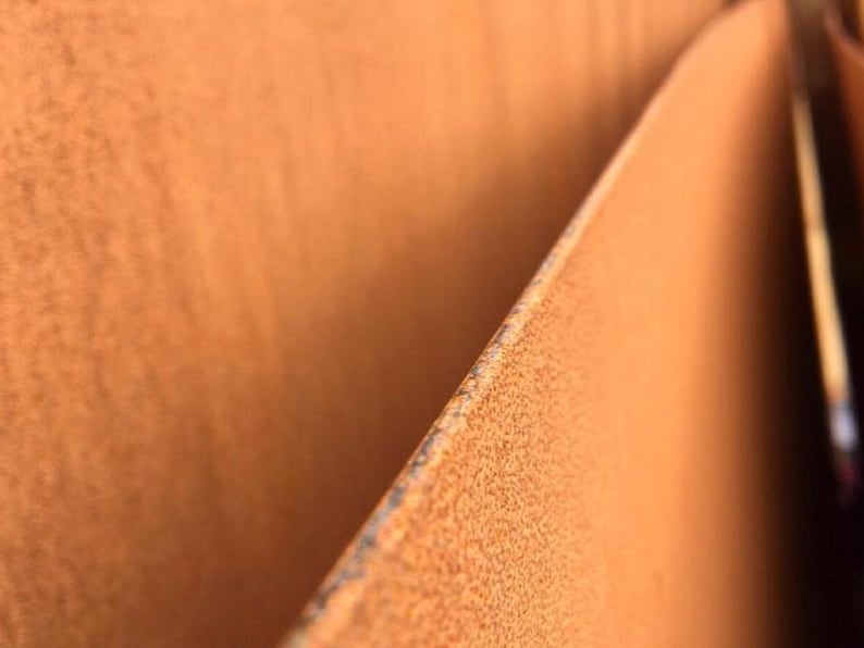 May include: Close-up of two pieces of rusted metal, showing the texture of the rust and the way the metal has been folded over.