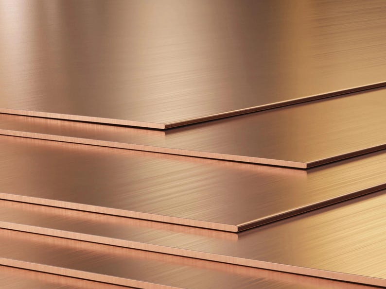 May include: Stack of four copper sheets with a brushed finish. The sheets are arranged in a staggered pattern, creating a layered effect.