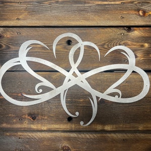 May include: A silver metal wall decor with a swirling, abstract design. The design is reminiscent of a stylized infinity symbol.