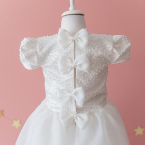Elegant Off-White Flower Girl Dress with Pearls, Satin Bows, and Matching Hair Accessory