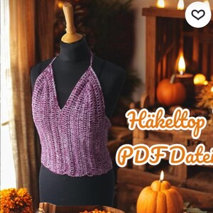 Puede incluir: Un top halter morado de ganchillo, exhibido en un maniqu&iacute; negro. El top tiene un dise&ntilde;o de cuello en V. La imagen tambi&eacute;n incluye el texto "H&auml;keltop PDF Datei".
