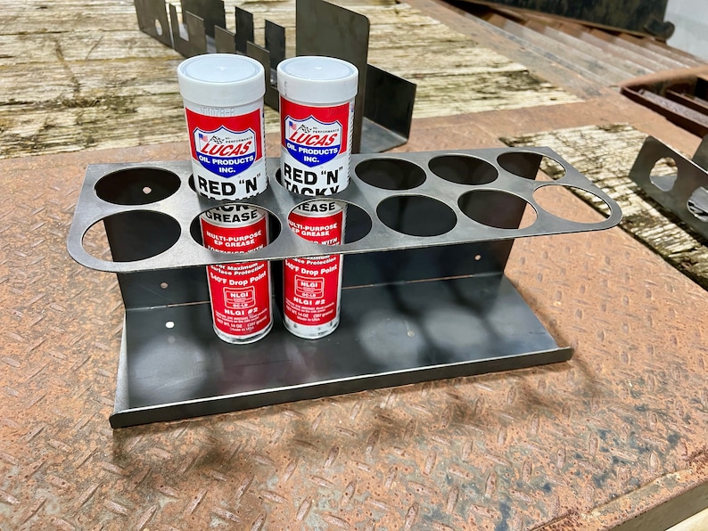 Peut inclure: Organisateur mural en m&eacute;tal avec six trous ronds pour contenir des tubes de graisse. Deux tubes de graisse multi-usages Lucas Red 'N Tacky sont dans l'organisateur.