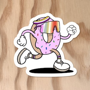Könnte beinhalten: Ein Aufkleber mit einem Cartoon-Donut mit rosa Zuckerguss und bunten Streuseln, der eine Sonnenbrille trägt und rennt. Der Donut hat Arme, Beine und weiße Schuhe. Der Hintergrund ist helles Holzmaserung.