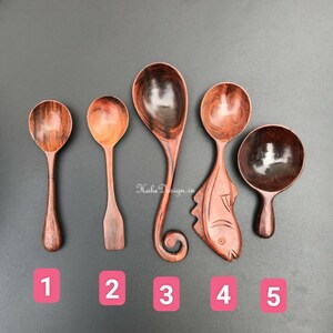May include: Five wooden spoons with different shapes and designs. The spoons are made of dark wood with a reddish hue. The spoons are numbered 1 through 5.