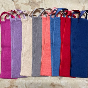 May include: Ten long, narrow, terry cloth towels with loops at each end. The towels are in various colors, including pink, purple, beige, gray, coral, blue, and red.