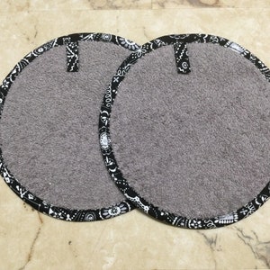 May include: Two gray round pot holders with black and white bandana print trim.