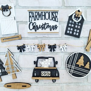 May include: A farmhouse Christmas themed craft kit with wooden cutouts of a truck, trees, a house, a door, a wreath, bows, and a sign that says "Farmhouse Christmas".