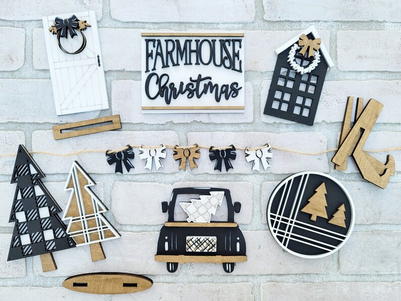 May include: A farmhouse Christmas themed craft kit with wooden cutouts of a truck, trees, a house, a door, a wreath, bows, and a sign that says "Farmhouse Christmas".