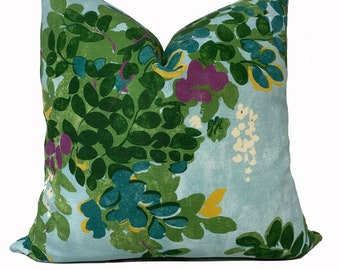 Pode incluir: Uma almofada azul claro com um padrão floral verde, turquesa, amarelo e roxo.