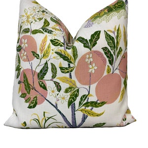 May include: A white pillow with a pink and green floral pattern. The pattern features pink citrus fruits, green leaves, and white flowers.