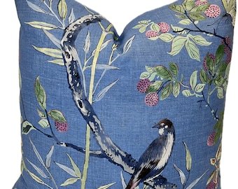 May include: A blue throw pillow with a floral pattern featuring birds, butterflies, and berries. The pillow has a light blue background with green leaves, yellow stems, and pink berries.