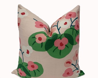 May include: A pink pillow with a floral pattern featuring pink and white flowers and green leaves.