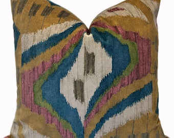 Puede incluir: Una almohada decorativa con un patrón geométrico en tonos marrones, azul verdoso, rosa y blanco.