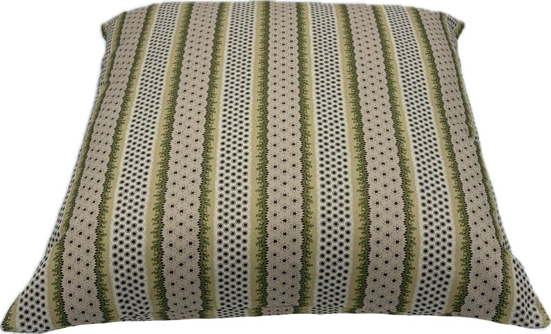 May include: Square decorative pillow with a striped pattern. The pillow features vertical stripes in beige, olive green, and black. The design includes dotted and floral elements, creating a textured appearance. The pillow is suitable for home decor.