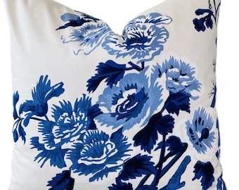 May include: A white pillow with a blue floral pattern. The flowers are large and have a stylized design. The pillow is perfect for adding a touch of elegance to any room.